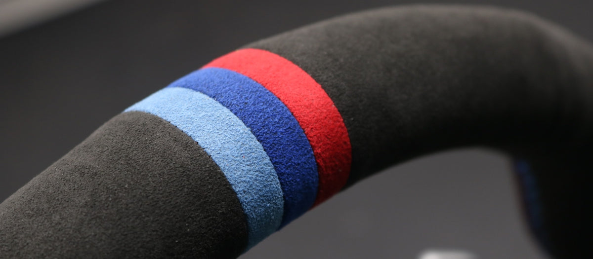 Nahaufnahme einer textilen Lenkradoberfläche mit hellblauem, blauem und rotem Marker
